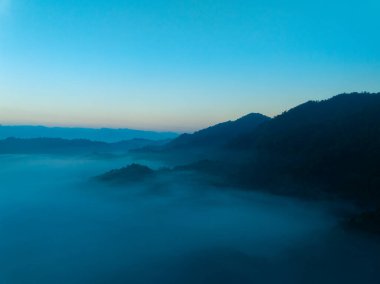 Tropikal yağmur ormanlarında akan sis dalgalarının hava görüntüsü bulutların üzerindeki kuş bakışı görüntü Tayland 'da bulutlar ve dağ zirveleriyle dolu arka plan.