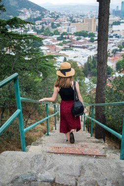 Şapkalı kadın merdivenlerden iniyor.