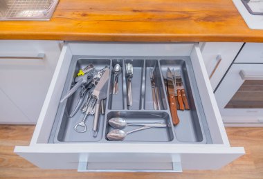 İçinde çatal bıçak takımı olan dolabı aç.