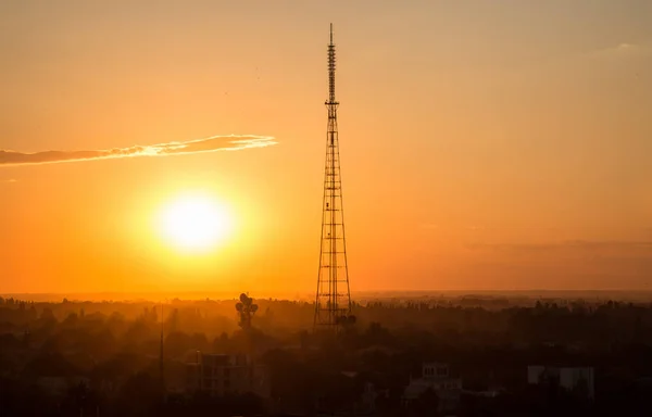 Stunning sunset in the city with the silhouette of a radio tower