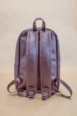 Kahverengi deri sırt çantaları bej arka planda. Uniseks çantası