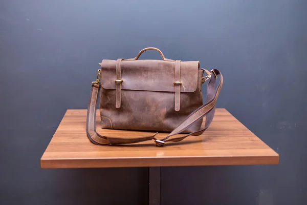 Brown leather backpacks on wood table. Unisex bag