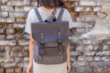 Sırt çantası gri olan bir kadın. Satılık üniforma çantası.