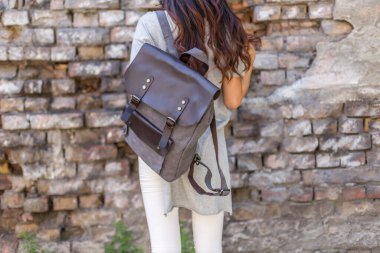 Sırt çantası gri olan bir kadın. Satılık üniforma çantası.