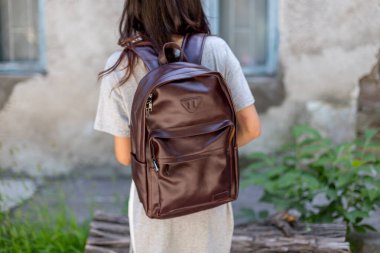 Kahverengi deri sırt çantalı bir kadın. Satılık Unisex çantası. Damgasız sırt çantası.