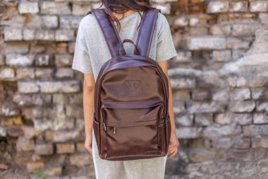 Kahverengi deri sırt çantalı bir kadın. Satılık Unisex çantası. Damgasız sırt çantası.