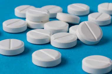 Mavi arka planda bir sürü hap var.