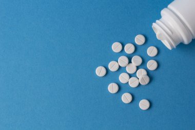 Mavi arka planda bir sürü hap var.