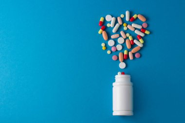 Mavi arka planda haplar, kapsüller ve vitaminler için kavanoz