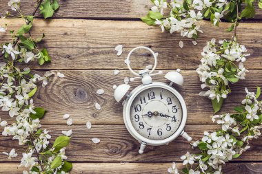 Ahşap arka plan üzerinde Elma çiçeği ve beyaz vintage çalar saat