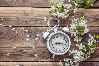 Ahşap arka plan üzerinde Elma çiçeği ve beyaz vintage çalar saat