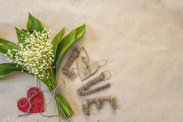 Background with bouquet of  lily of the valley and cardboard let — Stock Photo, Image
