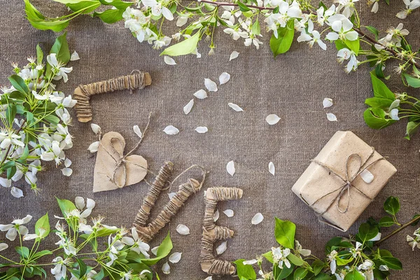 Fundo com flores de maçã, caixa de presente e cartas de papelão . — Fotografia de Stock