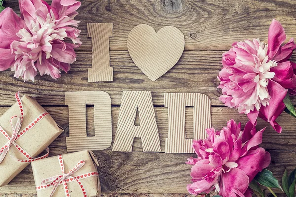 Fathers day background with cardboard letters, purple peonies an