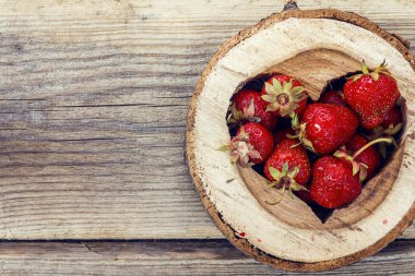 Eski woo tahtaya oyulmuş bir kalp içinde olgun çilek
