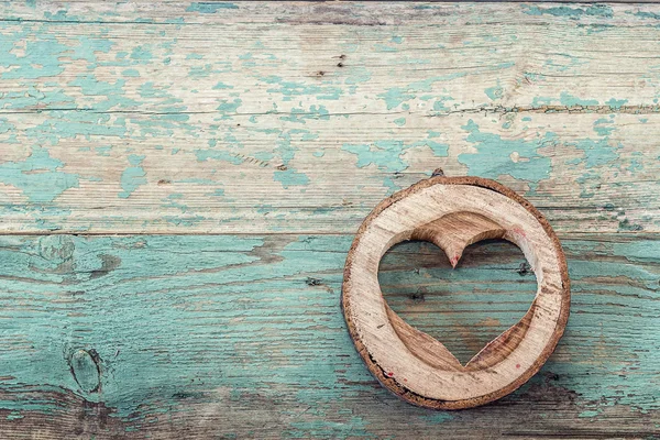 Heart shape carved in wood cut on the old turquoise boards.