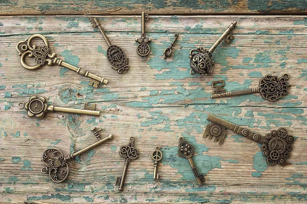 Background with round frame of antique keys on old painted woode