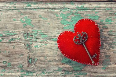Kırmızı kalp ile eski boyalı ahşap kurullarında antika anahtar.