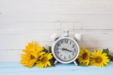 Arka plan beyaz çalar saat ve üzerinde beyaz woode ayçiçeği ile