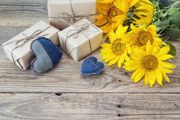 Sfondo con girasoli, confezione regalo e cuore su vecchio boa di legno — Foto Stock