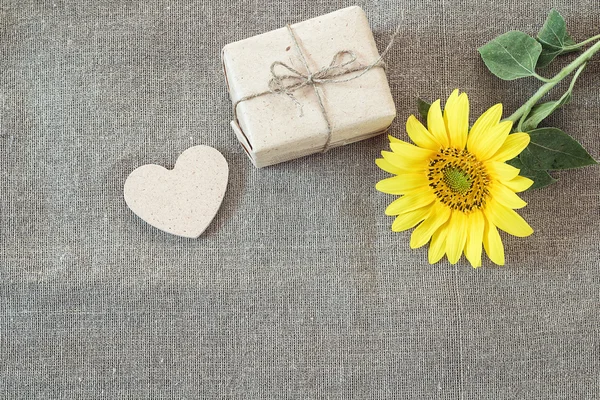 Achtergrond met zonnebloemen, doos van de gift en harten op de doek bu — Stockfoto