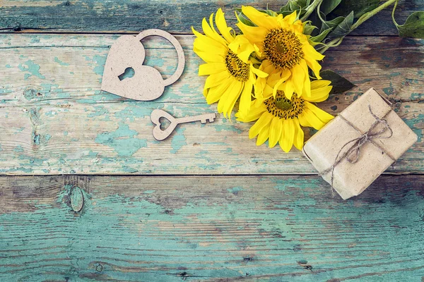 Фон з соняшниками, подарункові коробки, серце-замок і ключ на олі — стокове фото