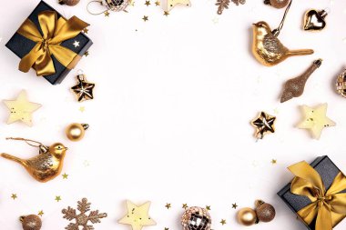 Beyaz arka planda altın süslemelerden yapılmış Noel çerçevesi. Boşluğu kopyala, üst görünüm, düz katman.