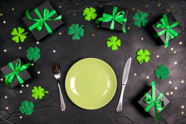 St. Patrick günü için sofra takımı ve siyah masada uğurlu semboller. Sayı kopyala, üst görünüm.