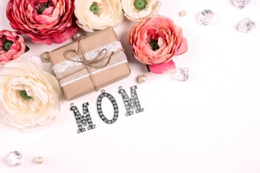 Şakayık çiçekli, hediyeli ve takı kelimeli beyaz bir geçmişi var anne. Fotokopi alanı olan üstten aşağı kompozisyon. Anneler Günü tebrik kartı..