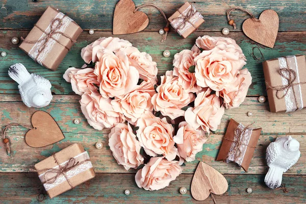 Festive background with rose flowers heart, gifts and birds on shabby wooden turquoise boards. Top down composition. Valentine\'s Day, Mother\'s Day or 8 March greeting card.