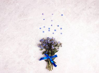 Hafif mermer arka planda küçük bir buket unutma beni. Metin için kopyalama alanı olan üst görünüm.