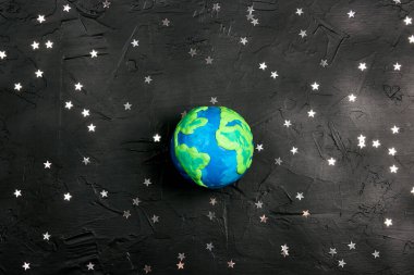 Siyah arka plandaki yıldızlar arasında Dünya gezegeni. Bilim, ekoloji, çevre koruma. Dünya Günü konsepti.