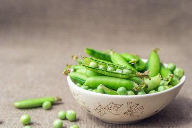 Arka plan bulanık bir kase içinde yeşil bezelye 