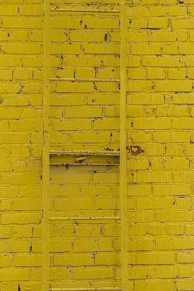 사다리와 노란 벽돌 벽의 질감 — 스톡 사진