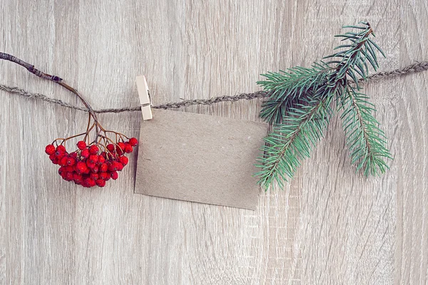 Christmas decorations with a blank card hanging over wooden back