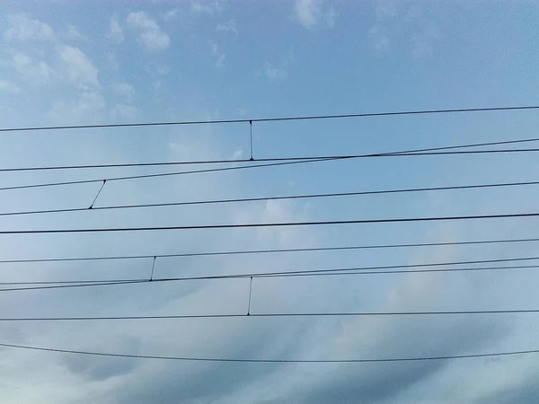 城市的电线 蓝天下连接在街道电线杆上的电缆 — 图库照片