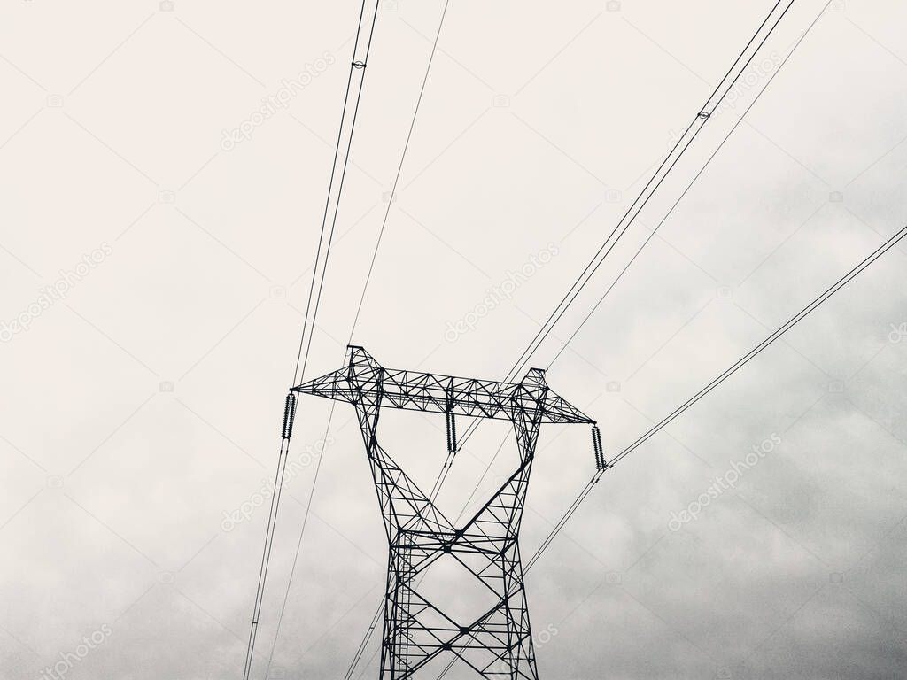 Power lines in the city. Electric cables attached to a street power pole under blue sky.