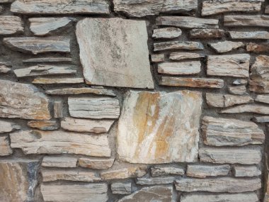 Taş duvar dokusunun arka planı. Düzensiz şekilli taşları olan kusursuz duvar. Granit kaldırım.