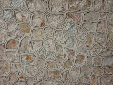 Taş duvar dokusunun arka planı. Düzensiz şekilli taşları olan kusursuz duvar. Granit kaldırım.