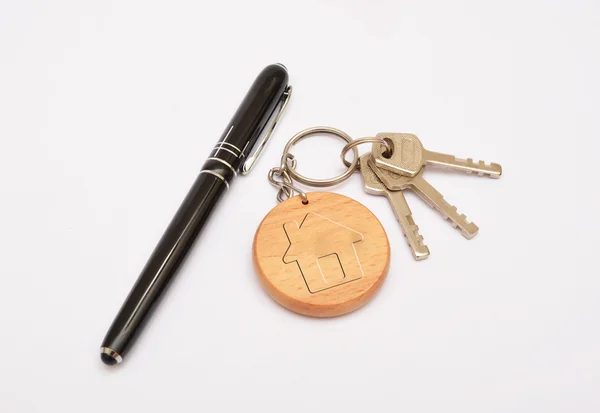 Metalen deur sleutels met pen en sleutelhanger geïsoleerd op witte achtergrond — Stockfoto