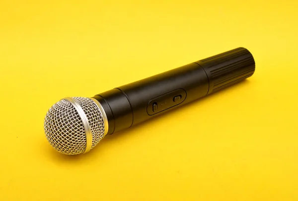 Draadloze microfoon op een gele achtergrond - motiverende spreker concept — Stockfoto