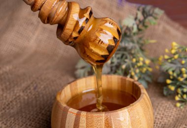 Kavanozda bal ve ahşap masa arka planında Dipper. Boşluğu kopyala.