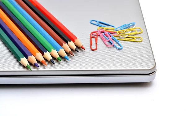 Lápices de colores con pasador de papel en el ordenador portátil —  Fotos de Stock