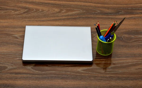 Material escolar com laptop sobre fundo de madeira — Fotografia de Stock