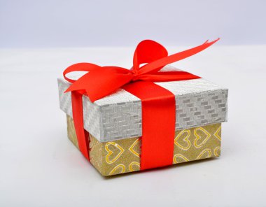 Kırmızı kurdeleli hediye kutusu beyaz üzerine izole