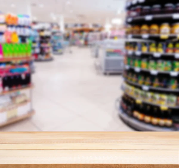 Wooden empty table in front of blurred supermarket