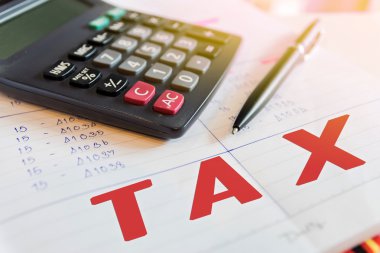 Calculator and pen  with words tax.