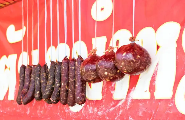 Βόειο κρέας και λουκάνικα από χοιρινό κρεμιούνται προς πώληση. — Φωτογραφία Αρχείου