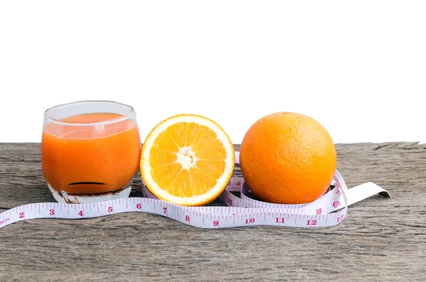 Portakal suyu ve portakal bir ahşap zemin üzerinde.