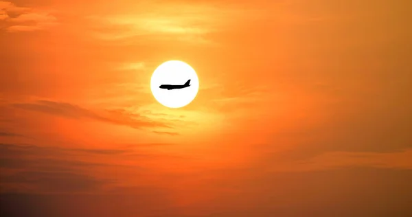 Silhueta de avião no belo sol e céu vermelho . — Fotografia de Stock